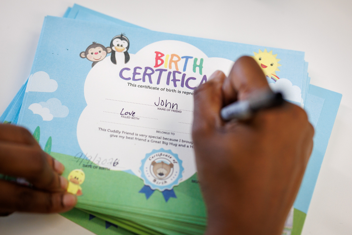 At Toot, Teach and Roll's third annual Furry Friend event at the children's hospital, Isiah James fills out his birth certificate for his new furry friend.